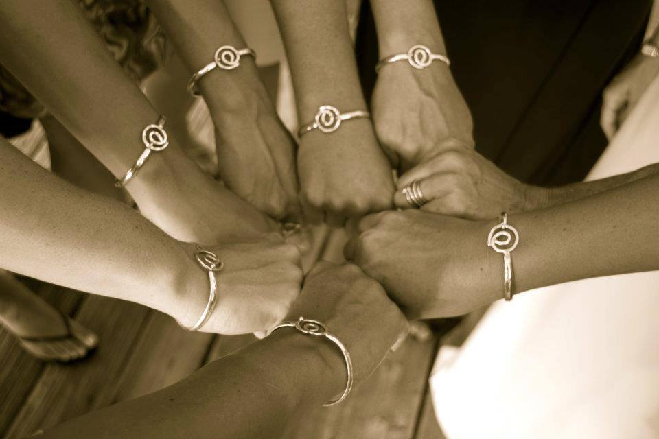 A group of friends wearing matching Hook bracelets from Joyia Jewelry in St. Croix